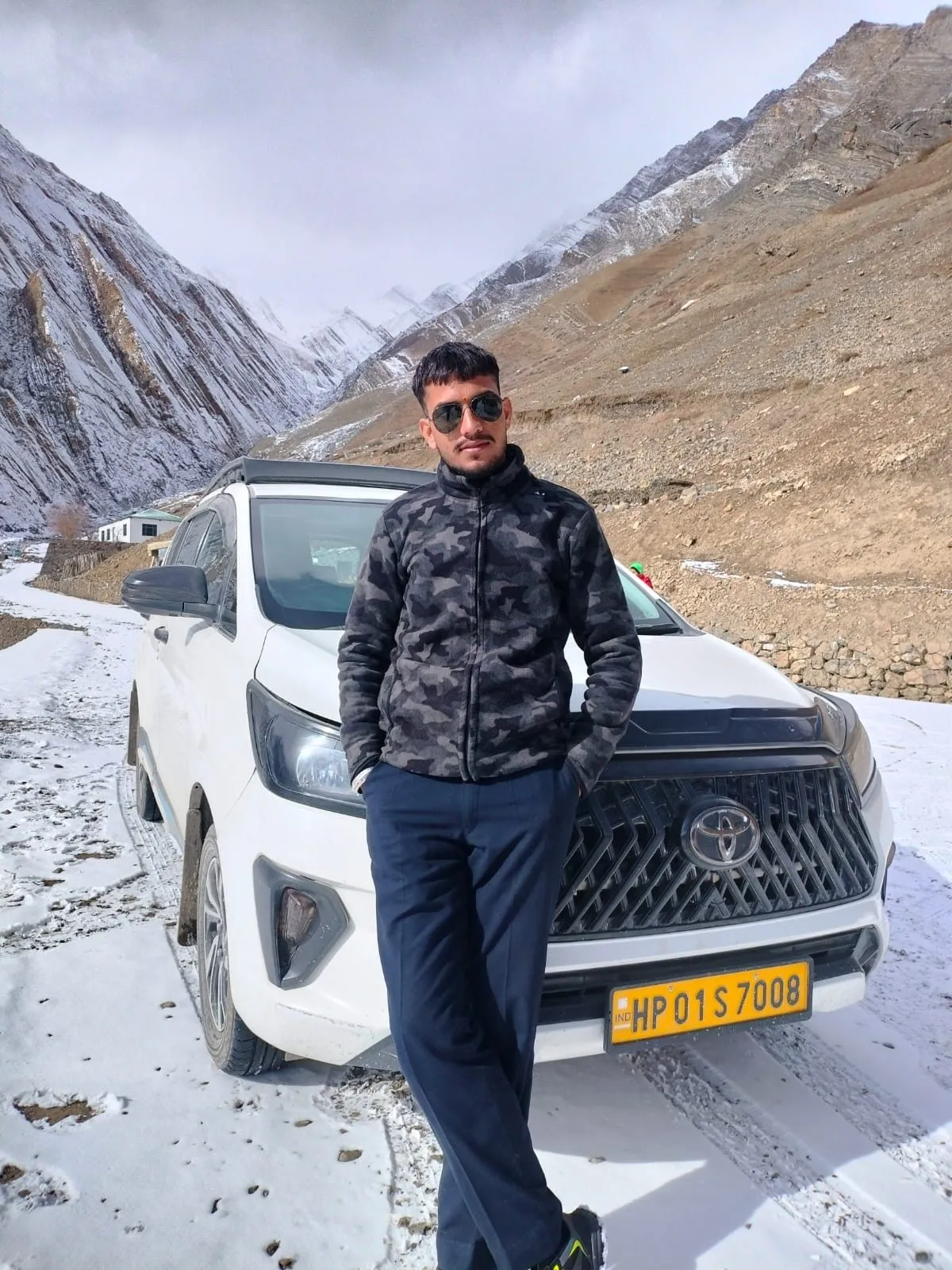 Kulwant beside his SUV on the snow-covered road near Pin Valley - Mudh Village